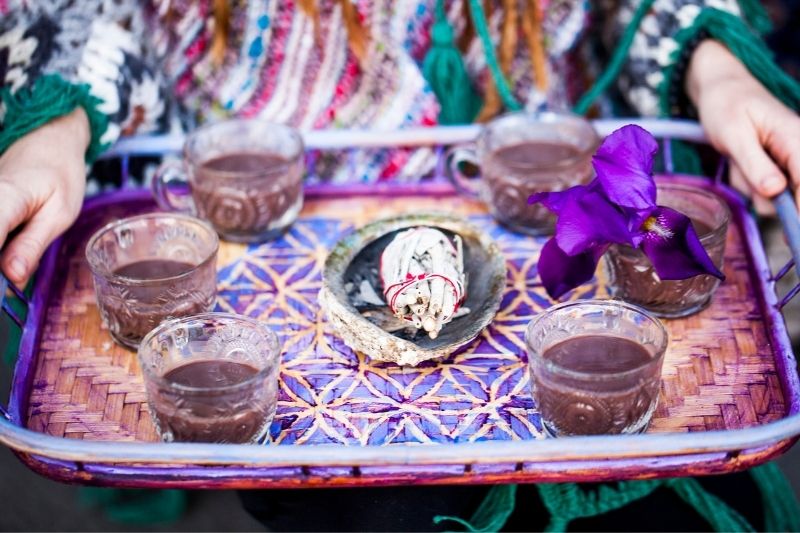 ceremonial cacao with sage being held on a tray
