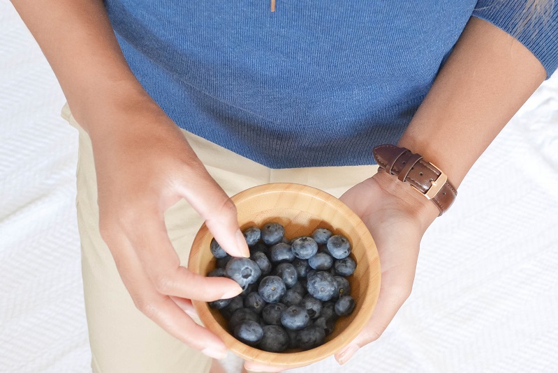 Woman eating blueberries for mental health