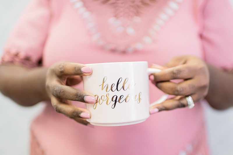 woman pink shirt with hello gorgeous coffee cup